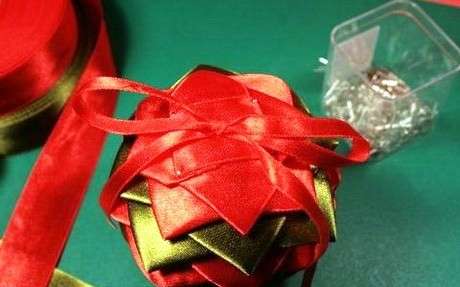 A labda többi részét szalagból készült négyzet segítségével kell díszíteni. A labda felakasztásához rögzítsen egy vékony szalagot. A szatén szalagok golyója készen áll.