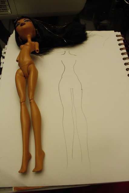 Przede wszystkim musisz narysować wzór na przyszłe kombinezony. Ponieważ same lalki Monster High są cienkie i smukłe, jest to łatwe. Weź kawałek papieru i ołówek. Zamknij lalkę i nakreśl kontury jej ciała. Uszyjemy kombinezon, więc zaznacz długość nogawek.