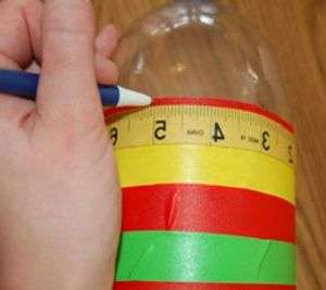 След това трябва да вземете сантиметър и да разделите бутилката на равни части от 1,5 см в кръг.