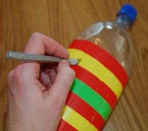 Za pomocą noża biurowego musisz przeciąć butelkę wzdłuż linii. Wystarczy wyciąć prostą część, która jest zaklejona taśmą elektryczną. Odległość do dna butelki powinna wynosić około 2-3 cm.
