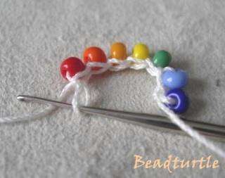 Next, our ring should be closed. To do this, you need to capture the thread after the bead that follows the blue bead.